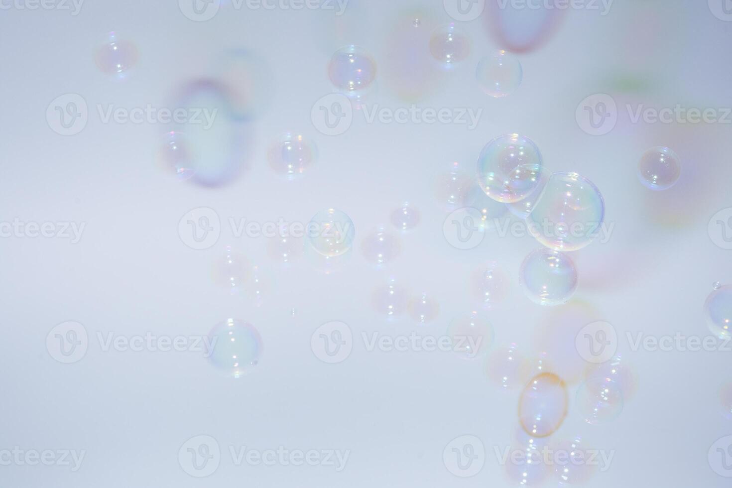 Soap bubbles floating in the air on a blue background photo