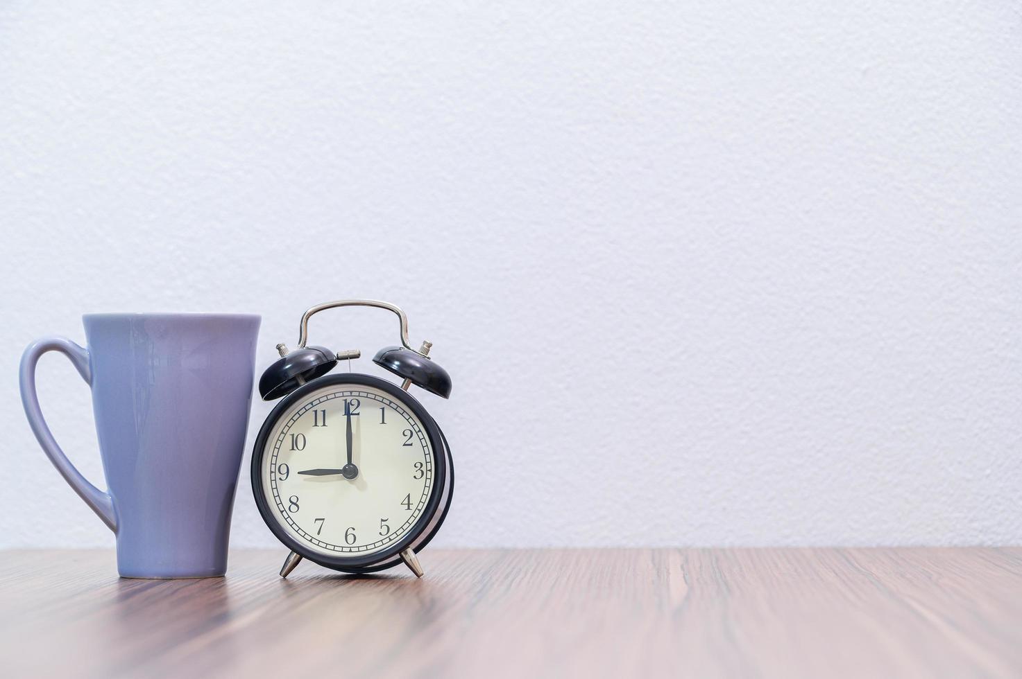 taza y reloj despertador en el escritorio foto