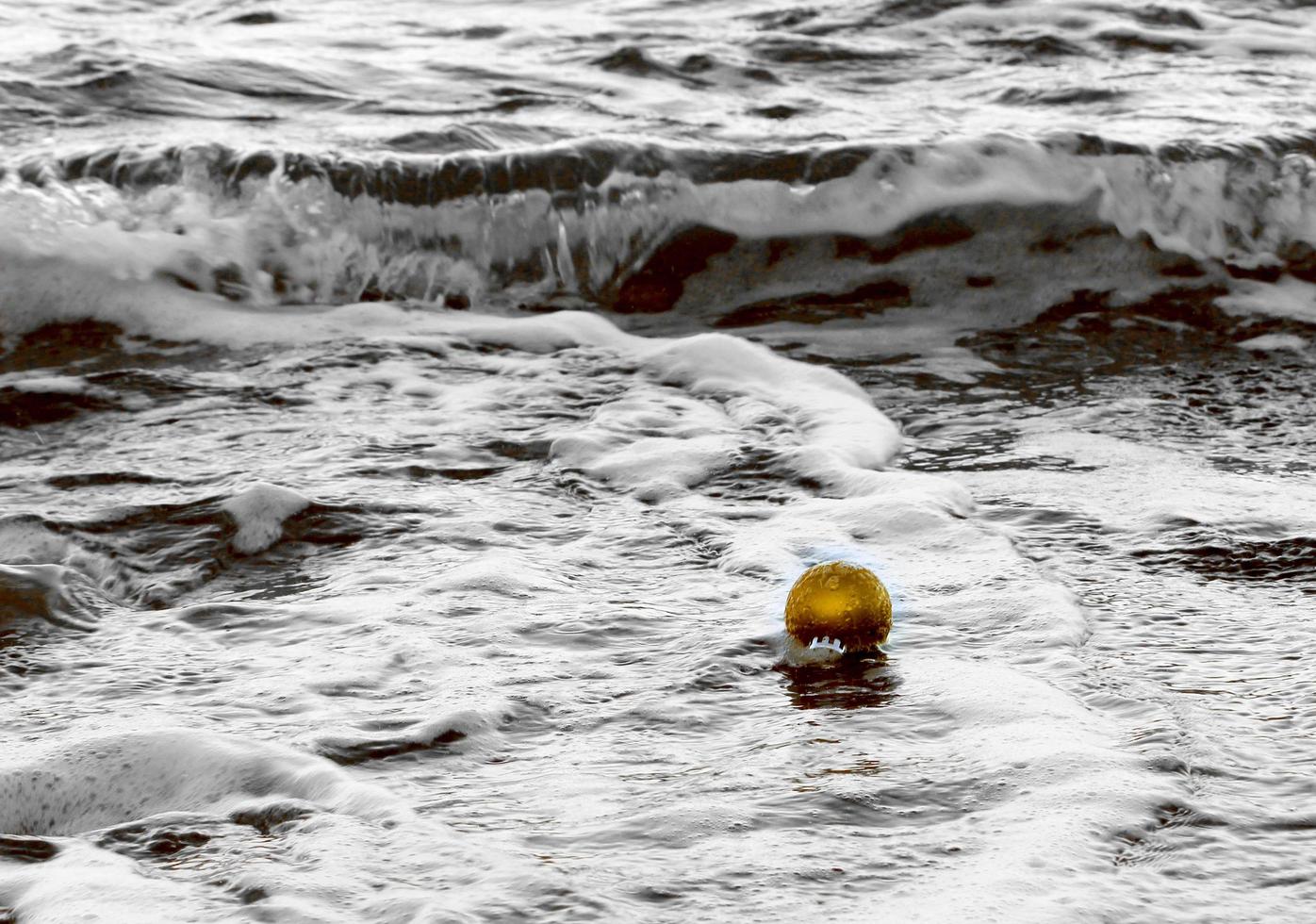 Golden Christmas ornament in the surf photo