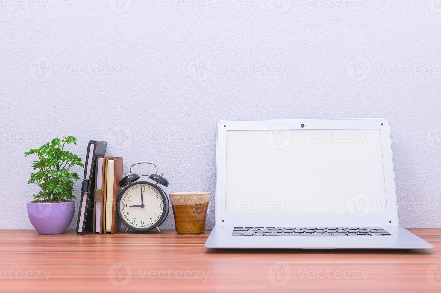 Laptop with blank screen and coffee on wooden desk photo