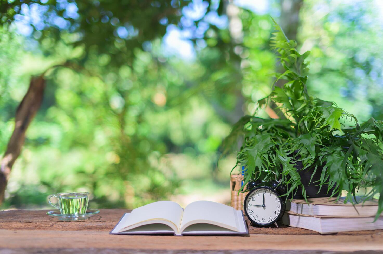 Books and alarm clock on the desk photo