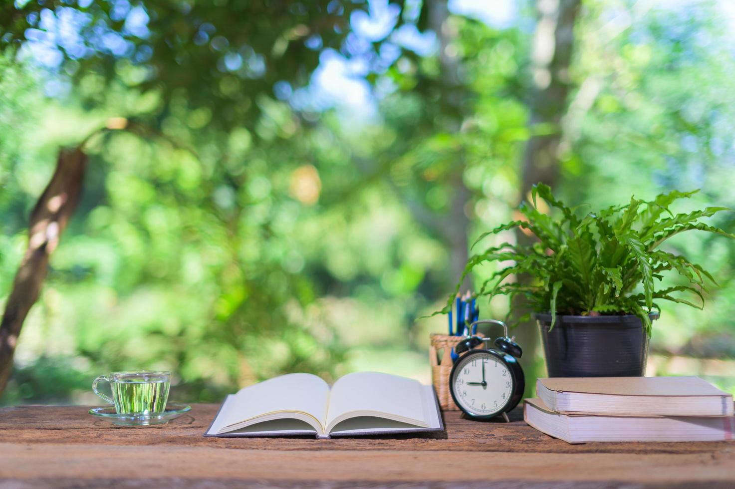 Books and alarm clock on the desk photo