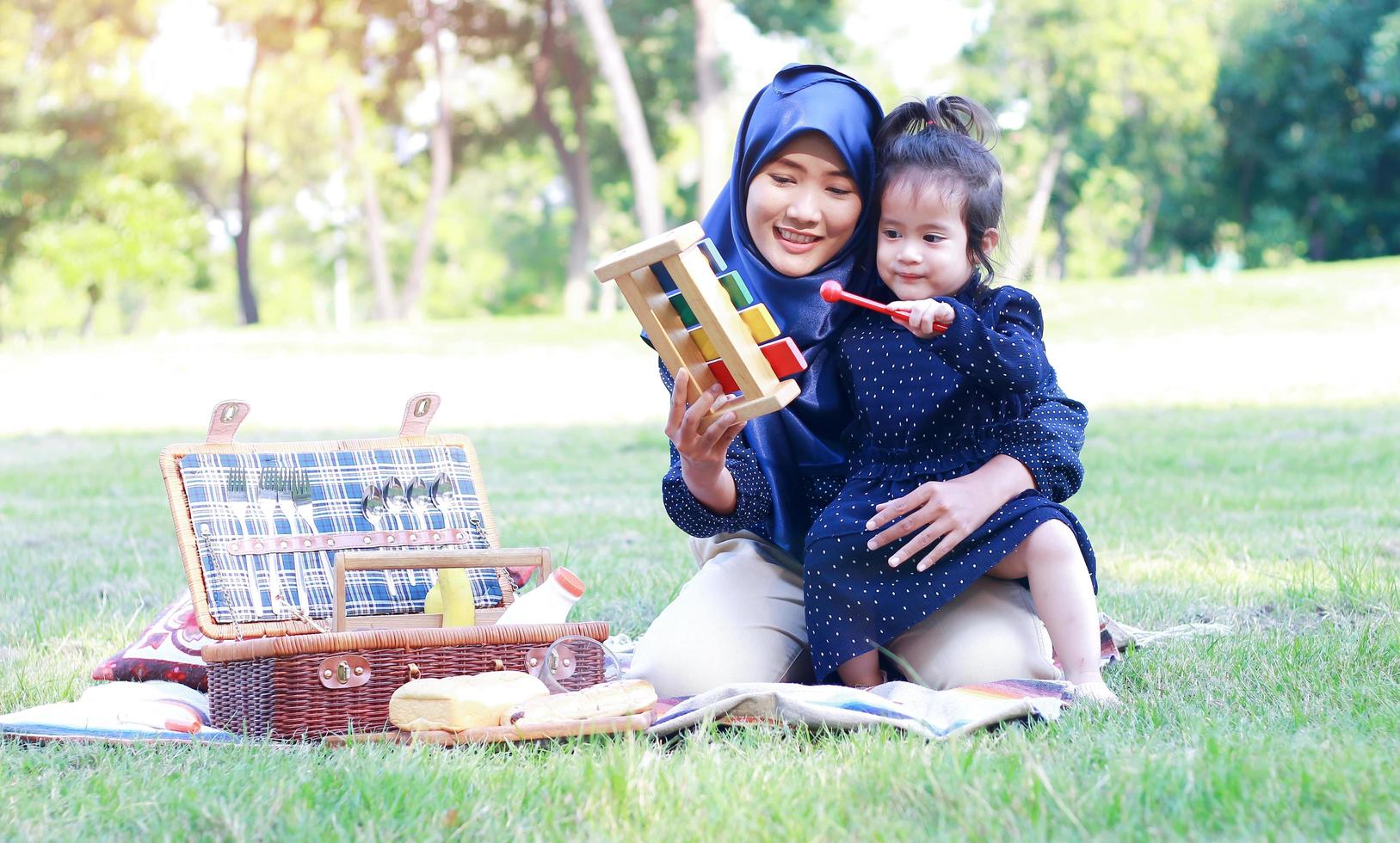 madres e hijas musulmanas disfrutan de sus vacaciones en el parque. amor y vínculo entre madre e hijo foto