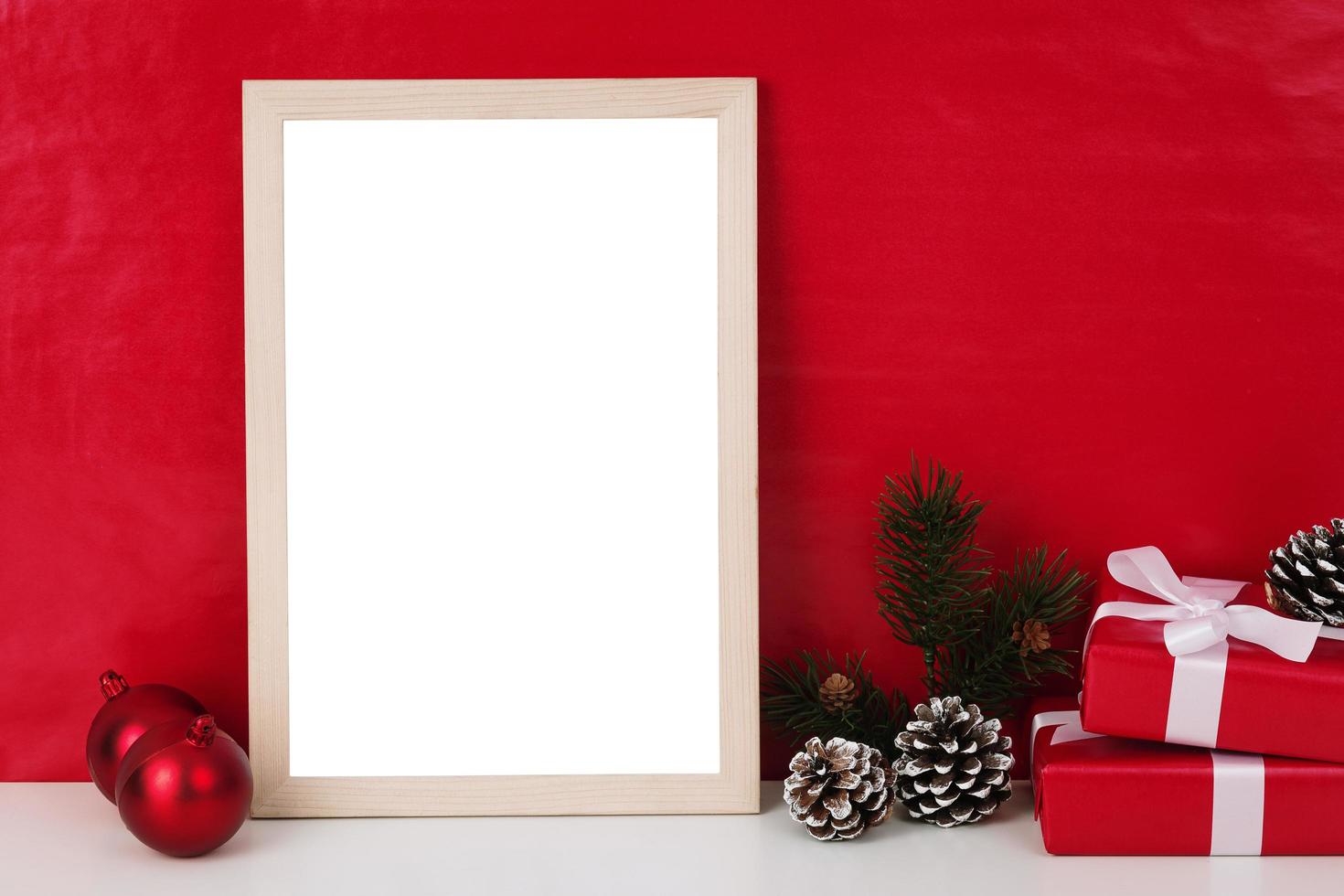 Plantilla de maqueta de marco de fotos de madera en blanco y decoración navideña sobre fondo rojo