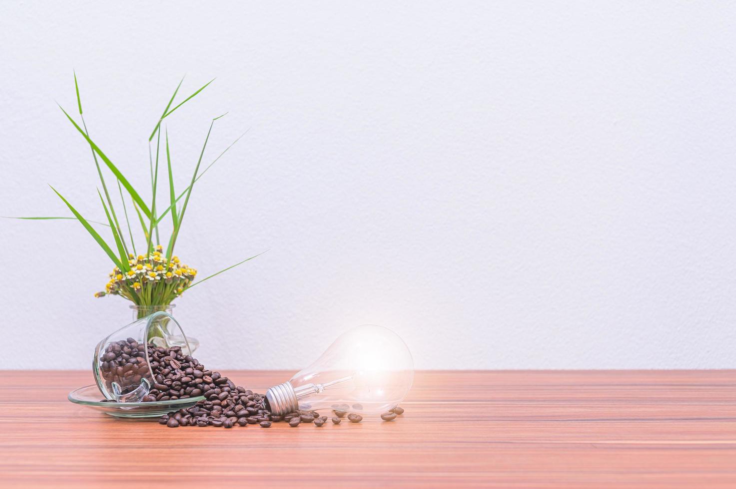 Mugs, coffee beans, and light bulbs on the desk photo