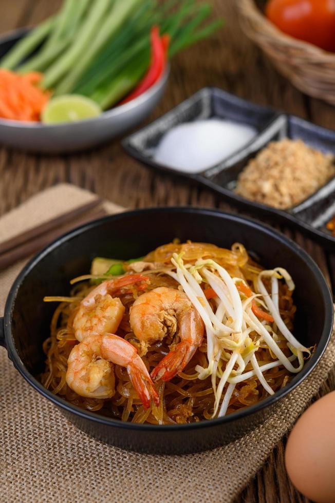 Pad thai shrimp in a black pan with eggs and seasoning photo