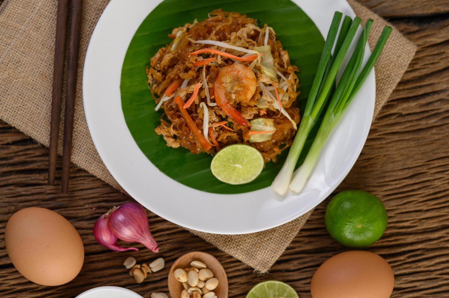 plato de pad thai camarones con limón y huevos foto