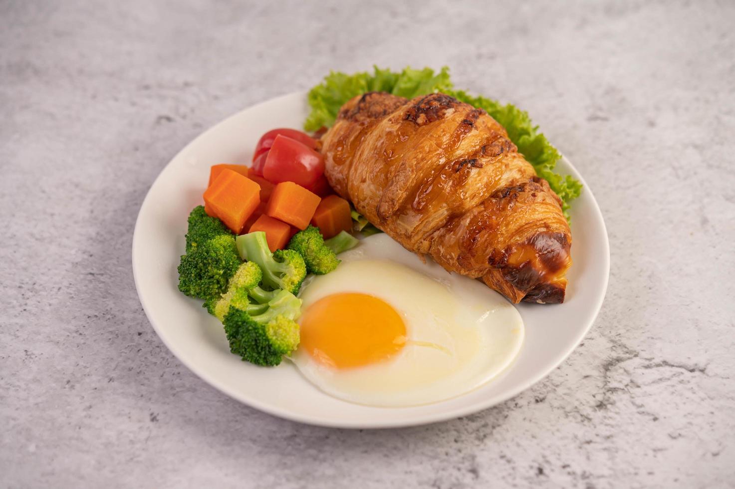 Fresh egg croissant and vegetable breakfast photo