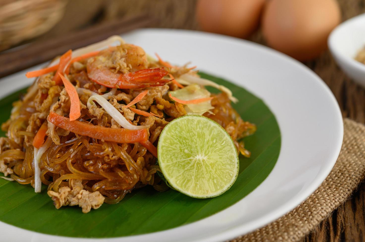 plato de pad thai camarones con limón y huevos foto