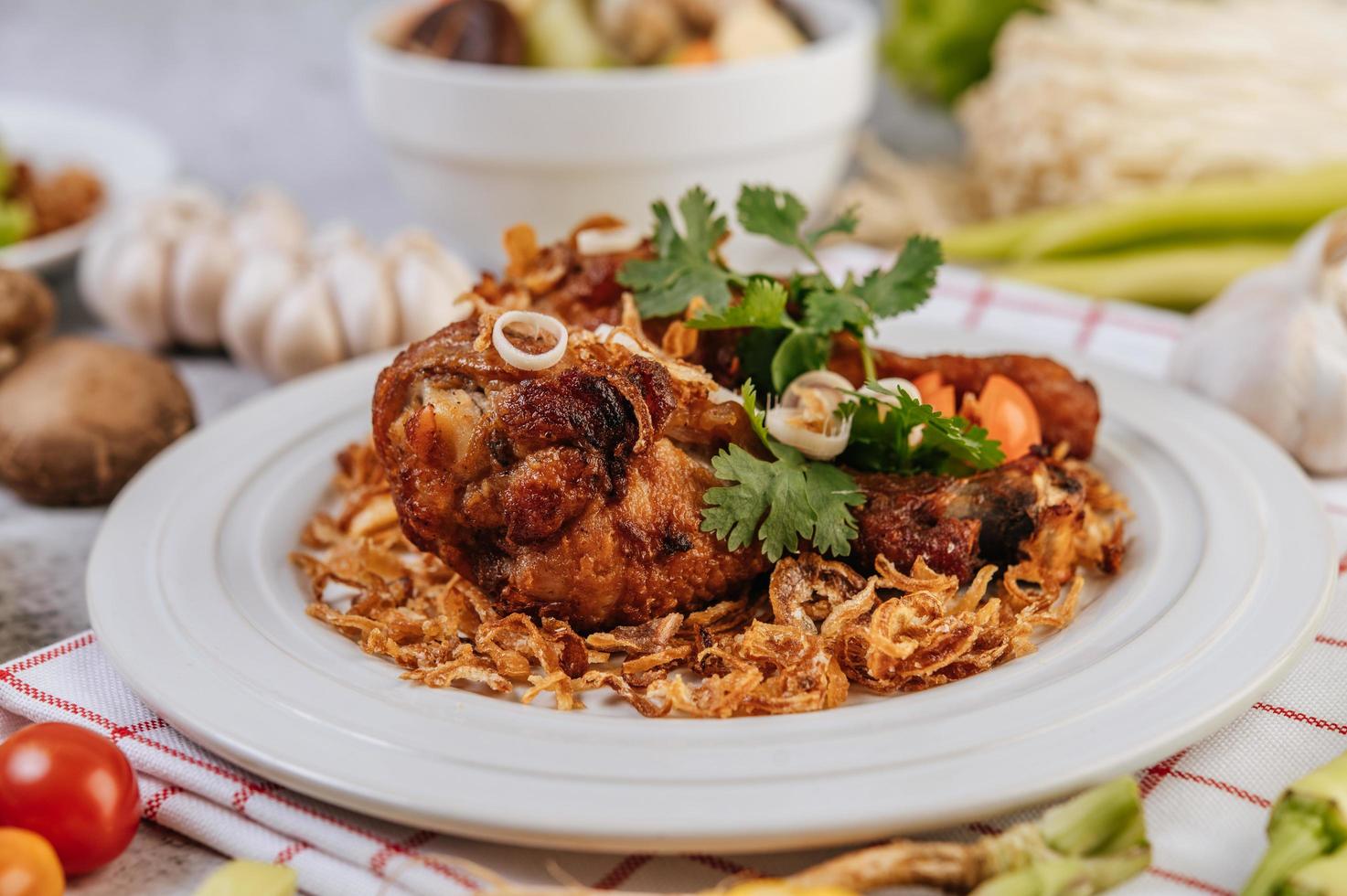 Fried chicken legs with tomato, chili, fried onion, lettuce, corn and mushroom photo