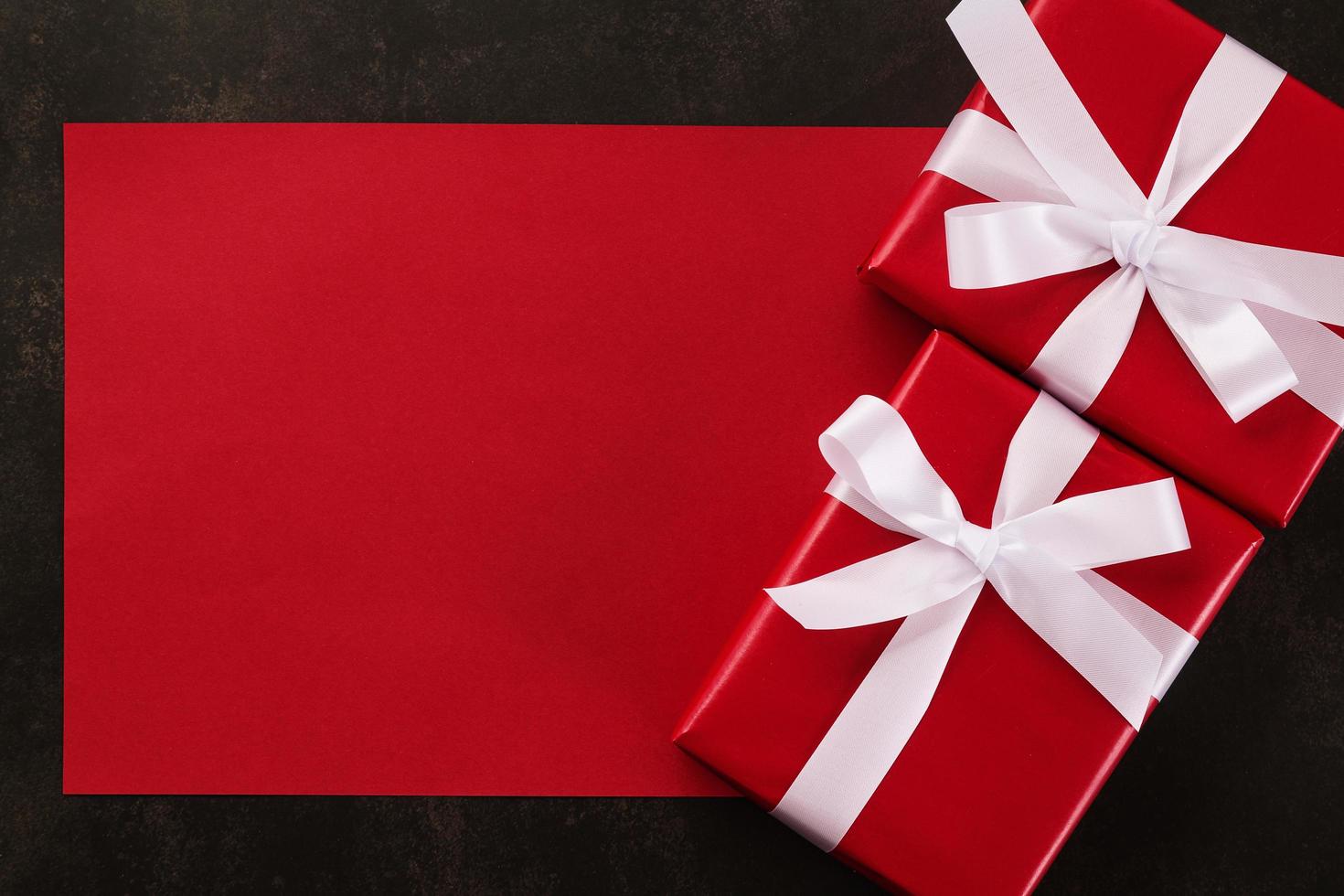 Maqueta de tarjeta de felicitación roja en blanco con adornos de regalo de Navidad sobre fondo grunge foto