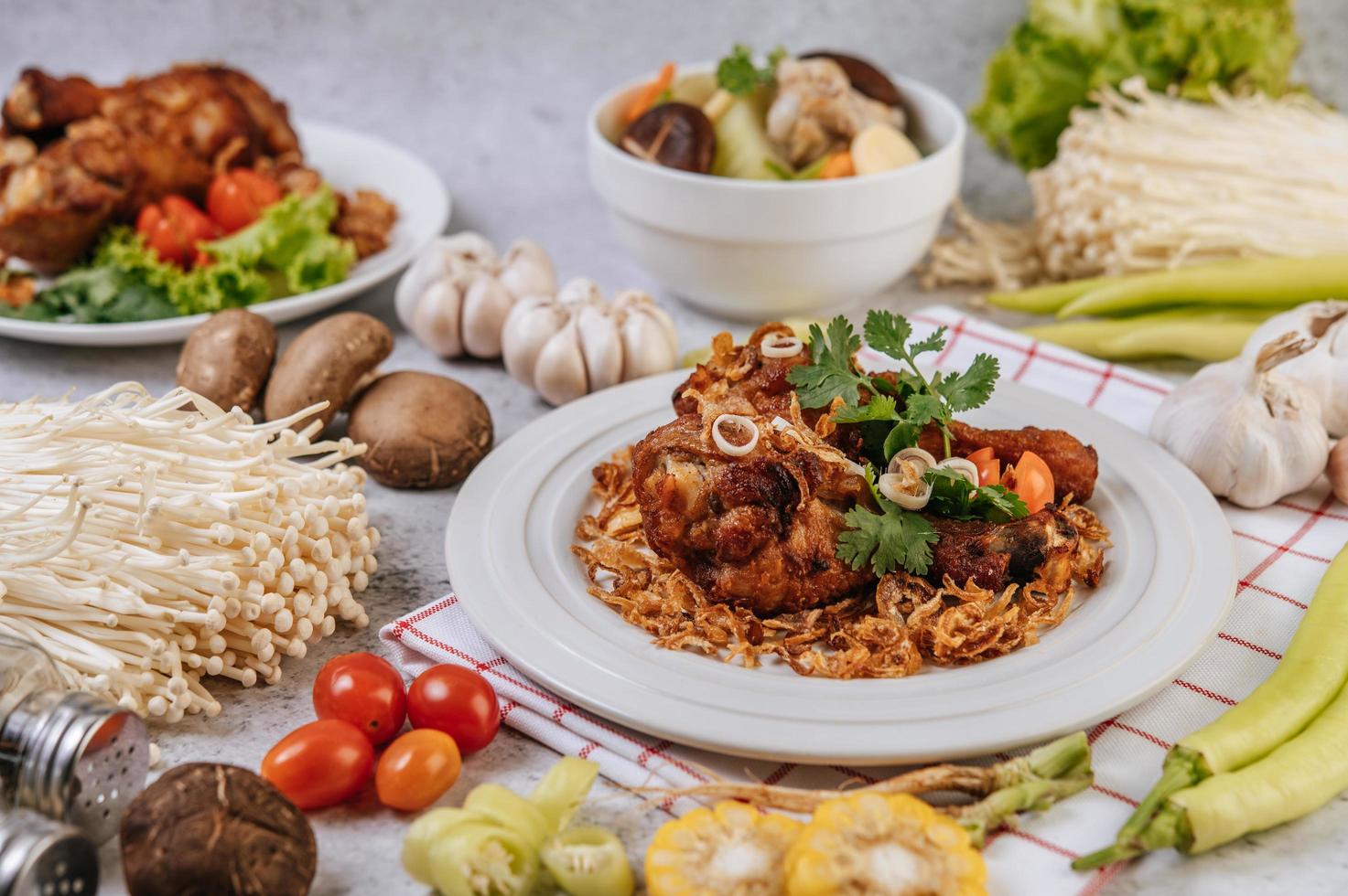 Fried chicken legs with tomato, chili, fried onion, lettuce, corn and mushroom photo