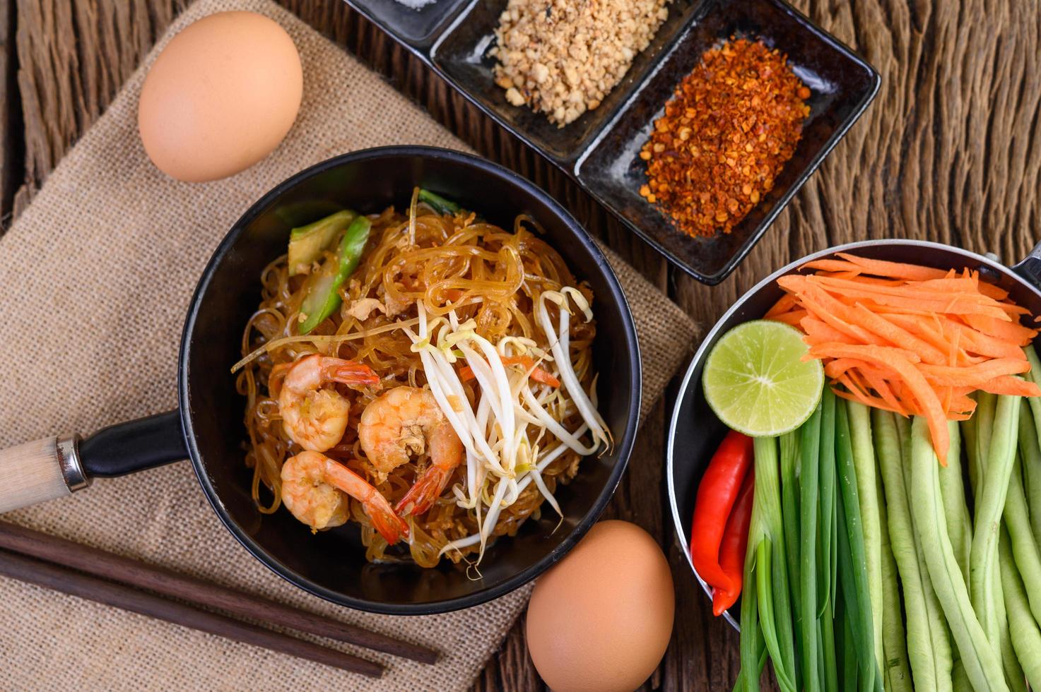 Pad thai shrimp in a black pan with eggs and seasoning photo