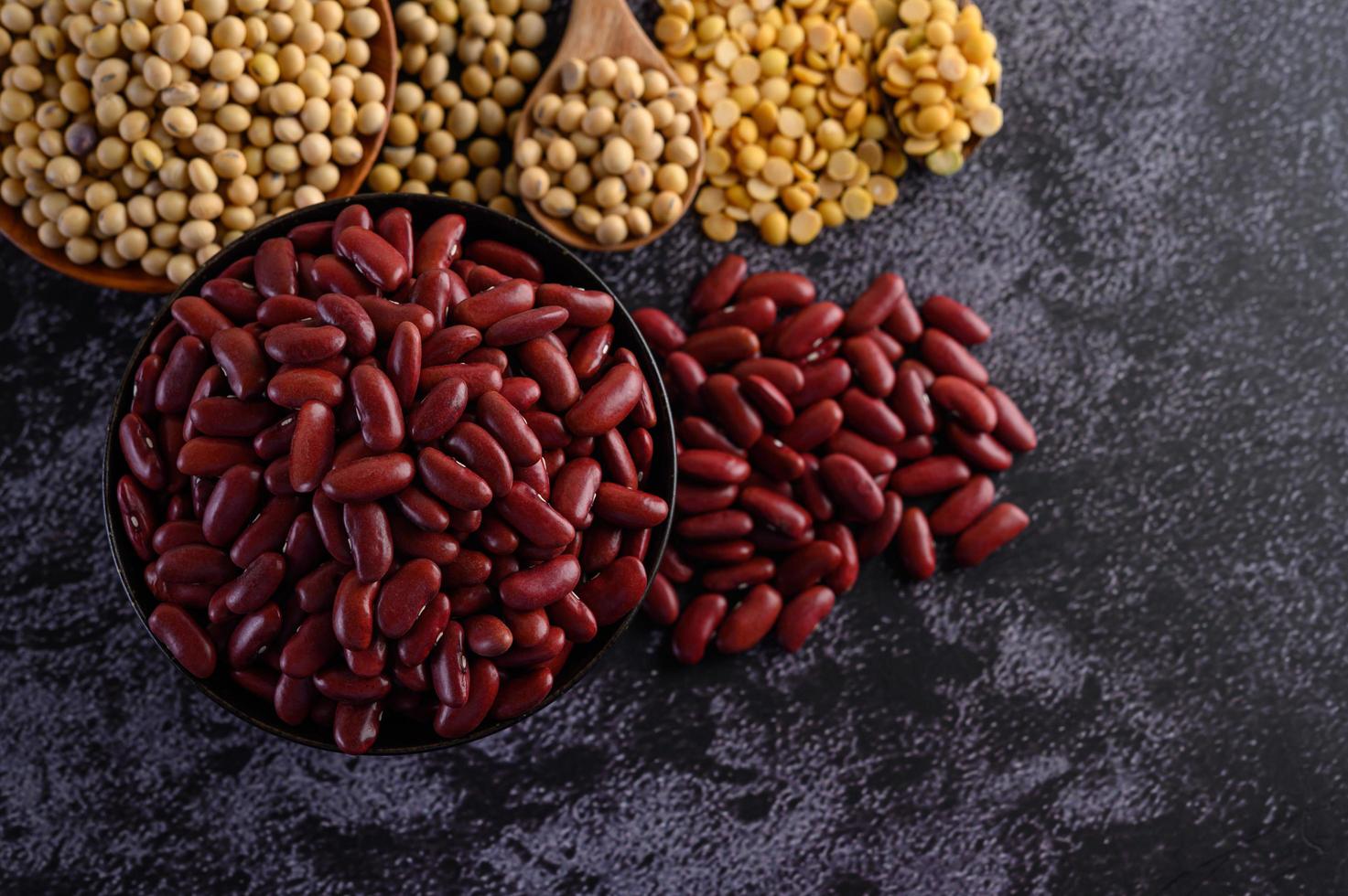 frijoles rojos en un cuenco de madera y una cuchara marrón foto