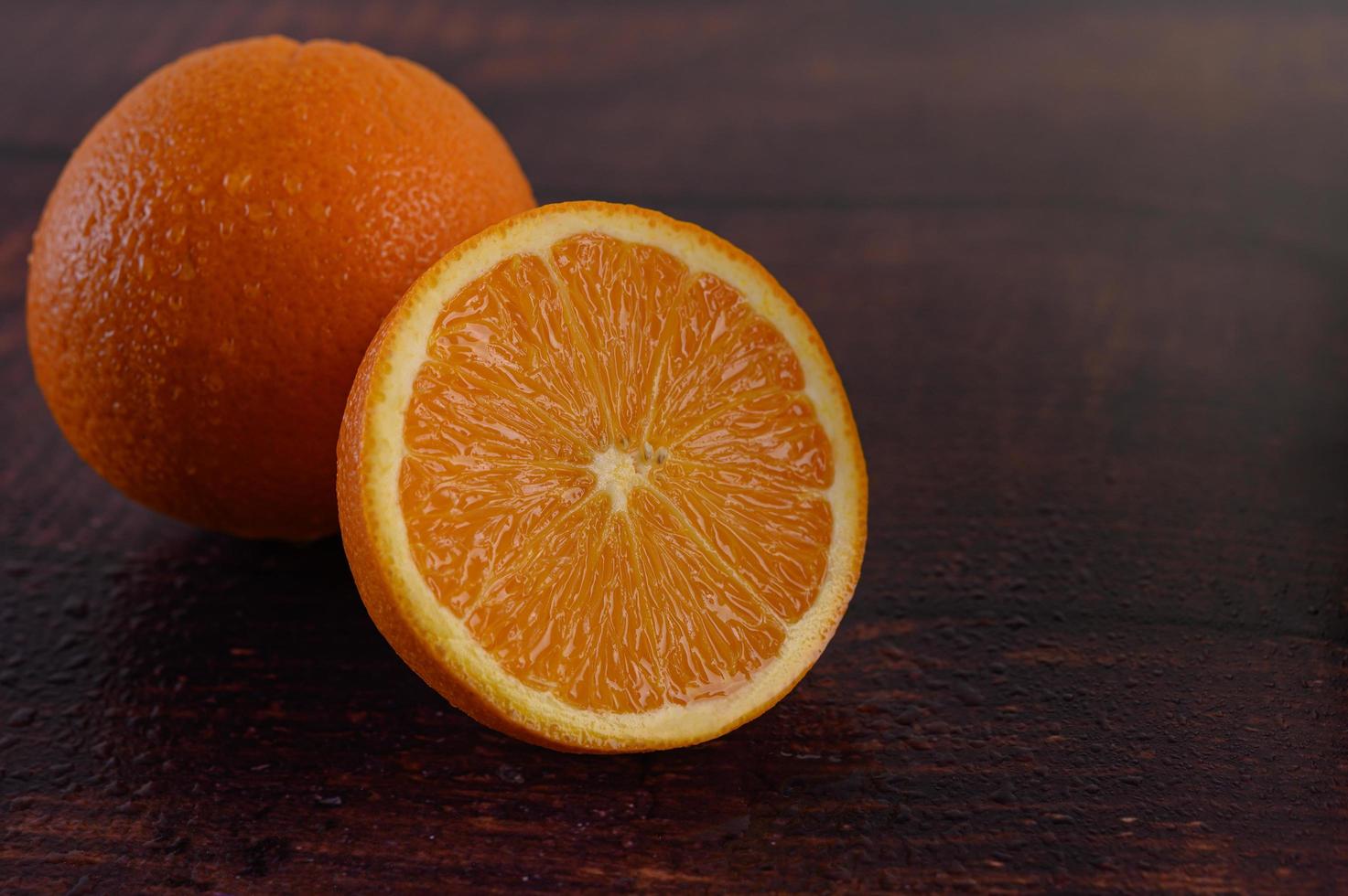 Macro image of a ripe orange on wood background photo