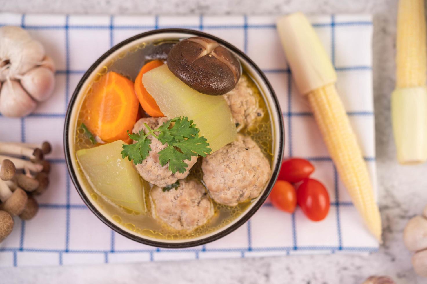 Pork meatball soup surrounded by ingredients photo