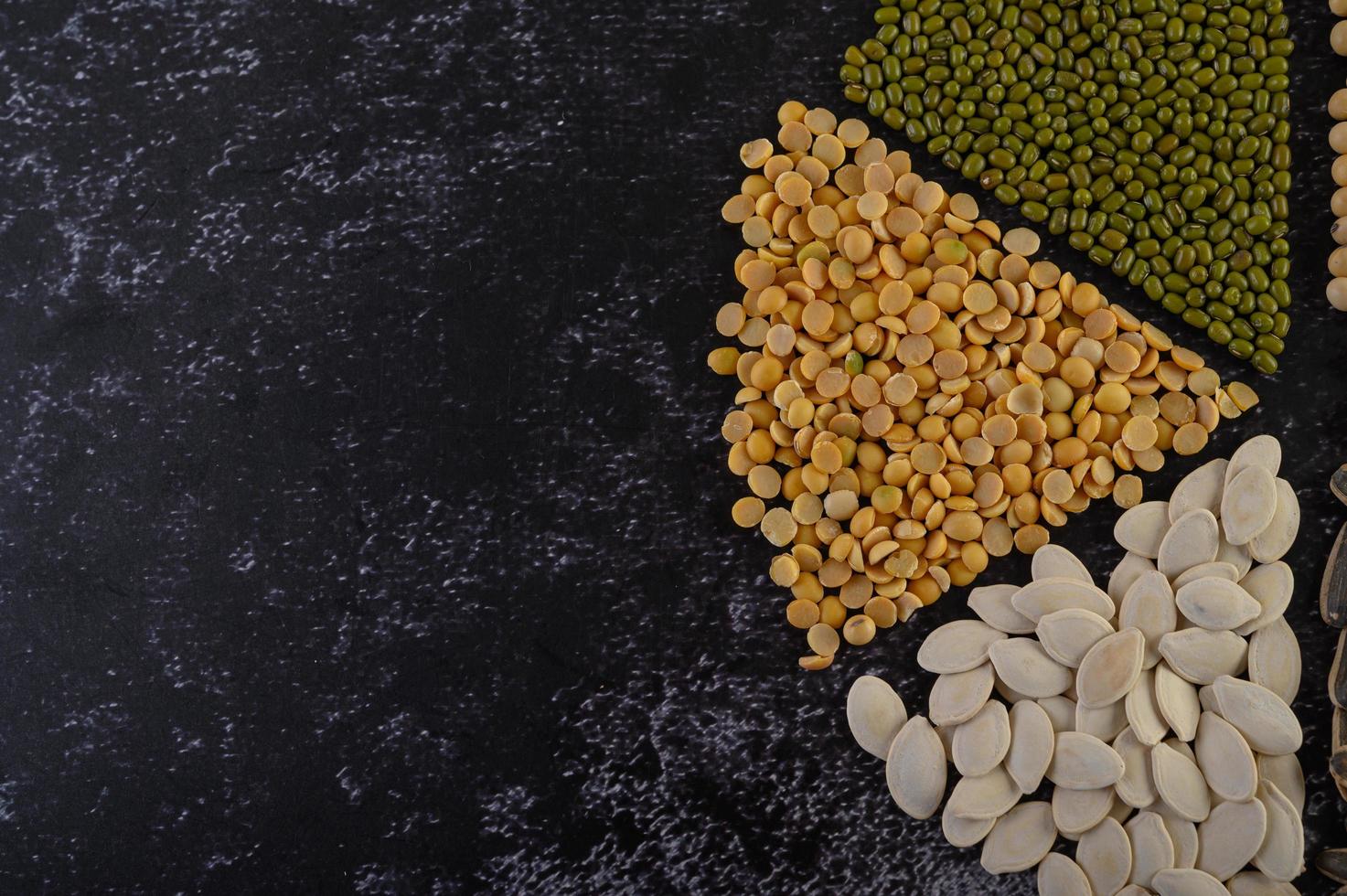 Legumes arranged in a circle on a black cement surface photo