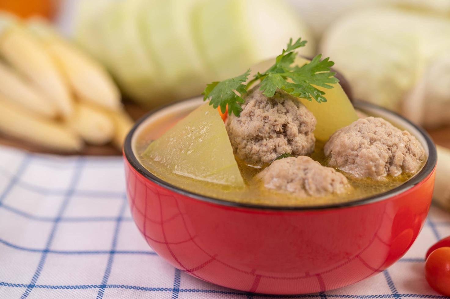 Pork meatball soup surrounded by ingredients photo