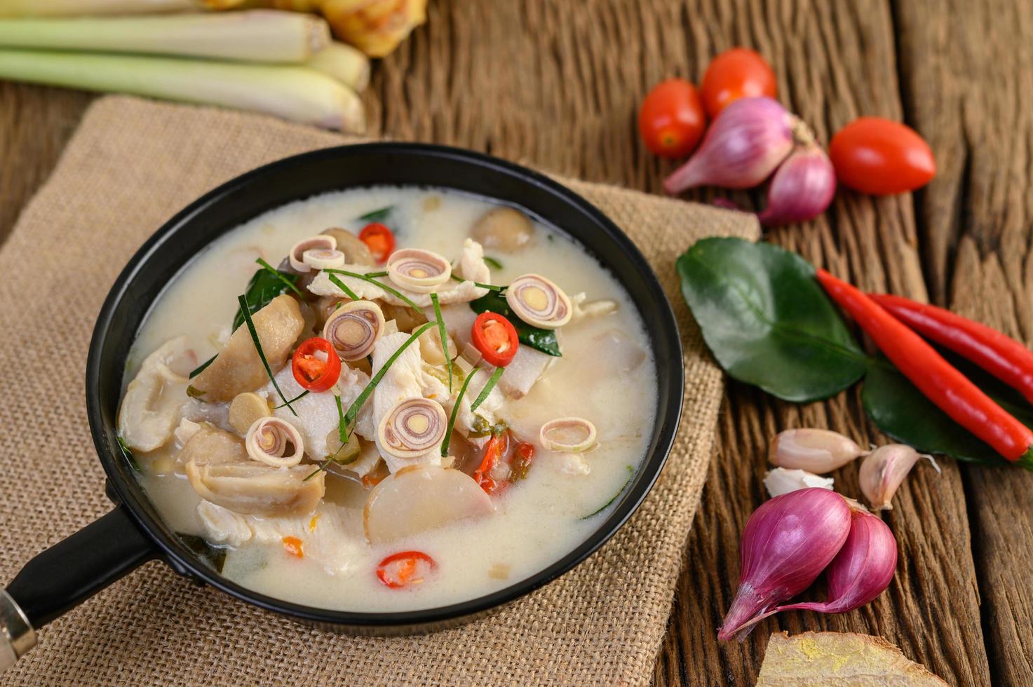 sopa tom kha kai con hojas de lima kaffir, limoncillo, cebolla morada, galanga y chile foto