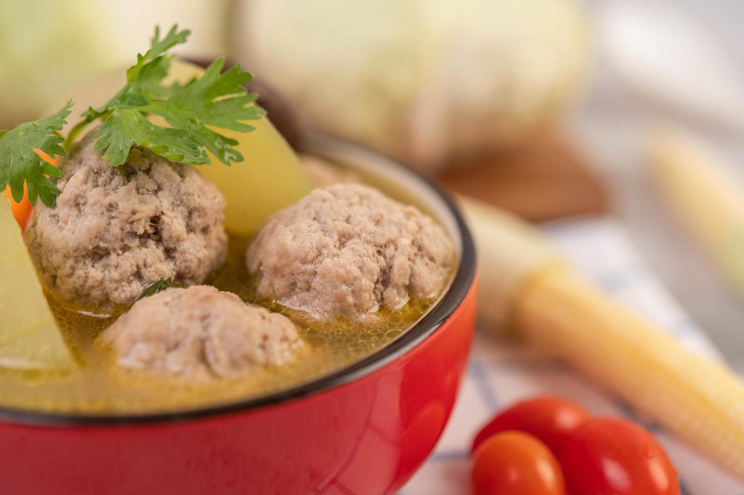 sopa de albóndigas de cerdo rodeada de ingredientes foto