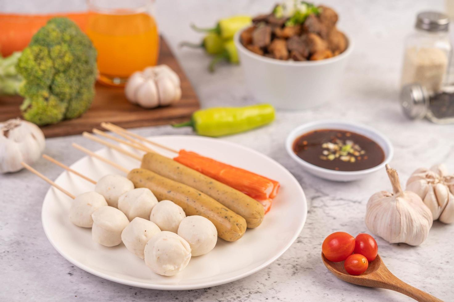 Pork meatballs and skewers with sausage and vegetables photo