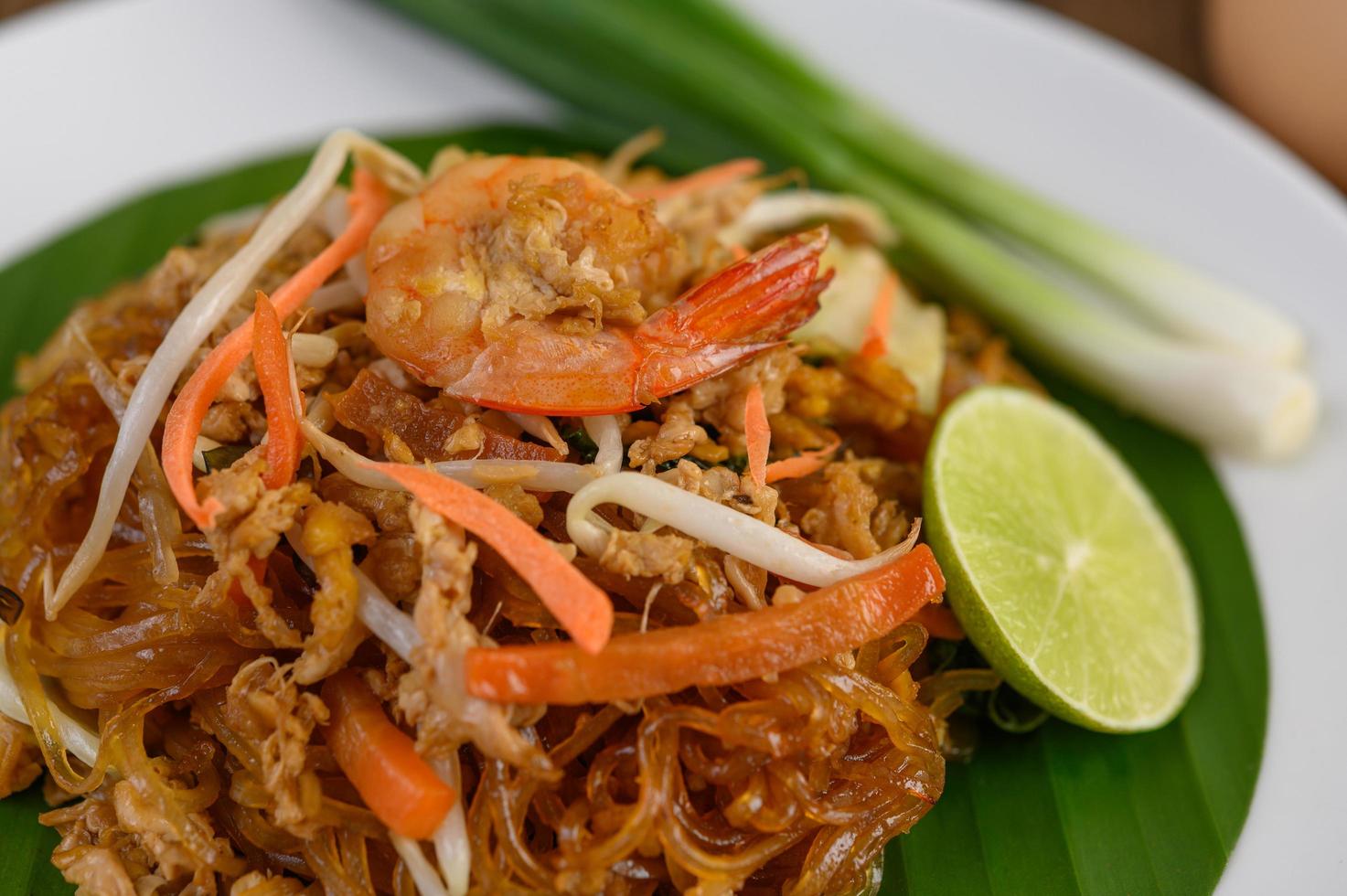 Plate of pad thai shrimp with lime and eggs photo