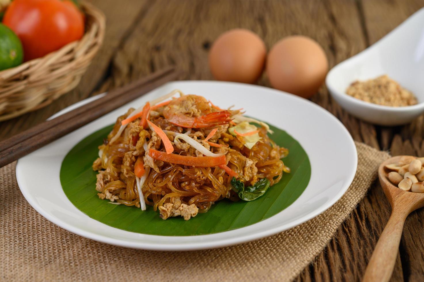 pad thai camarones en un bol con huevos, cebolleta y condimentos foto