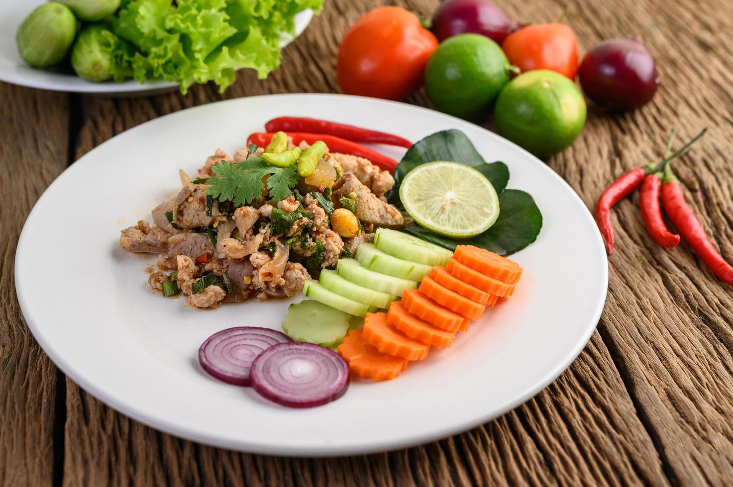 Minced pork salad with spices on a wooden table photo