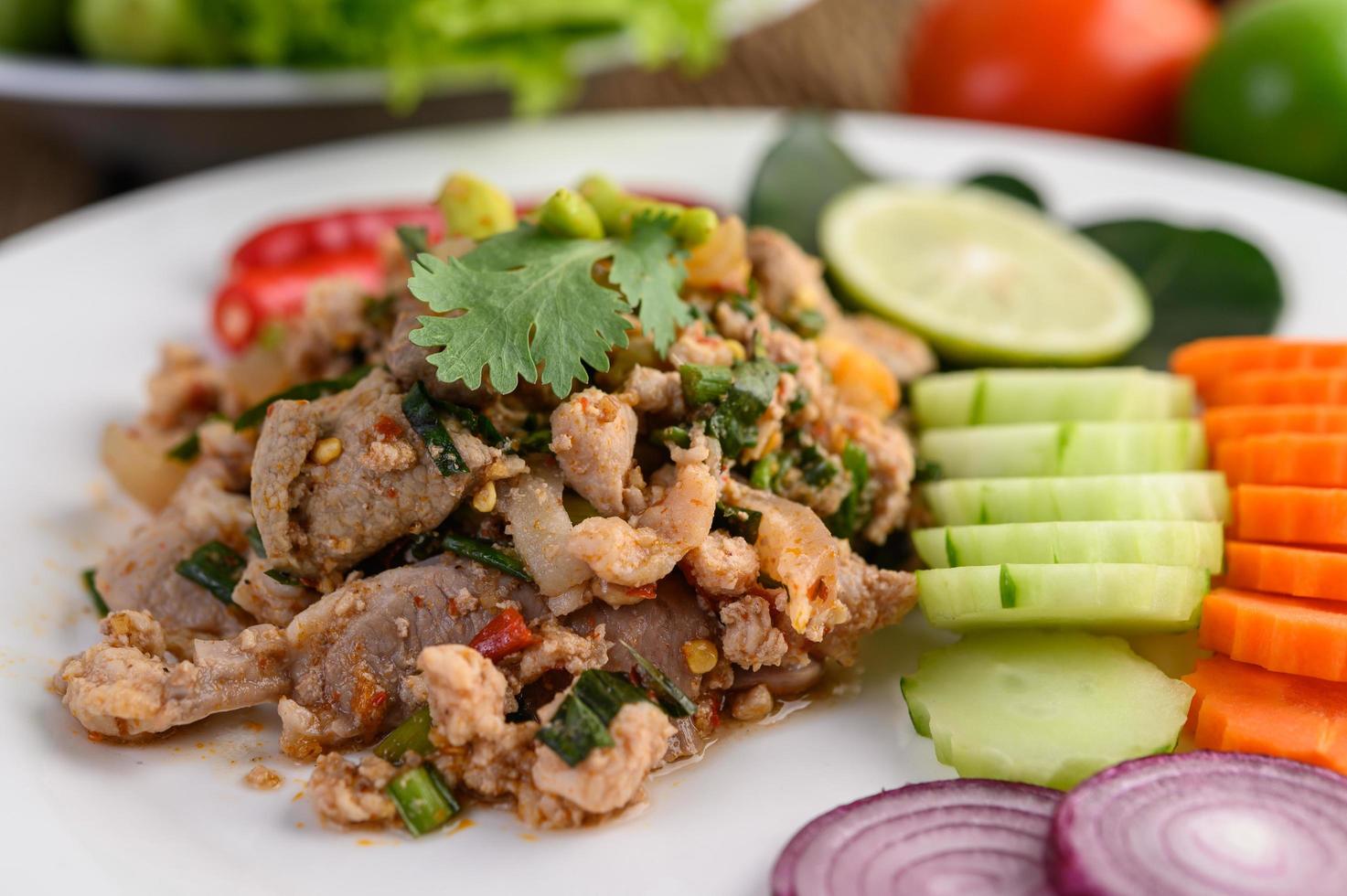 Minced pork salad with spices on a wooden table photo