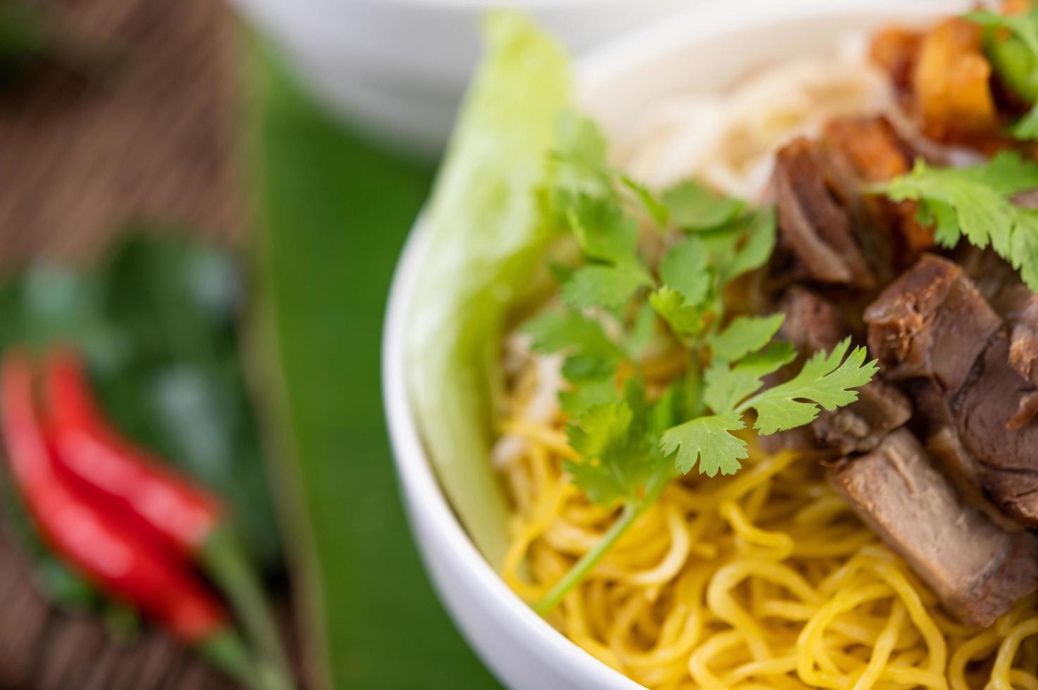 Yellow noodles with crispy pork and meatballs photo