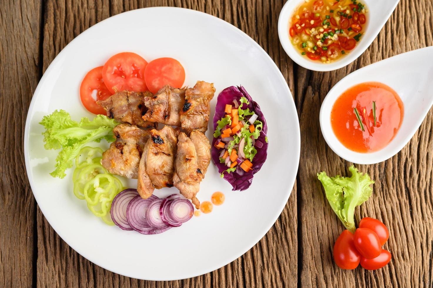 Grilled chicken on a wood cutting board with salad photo