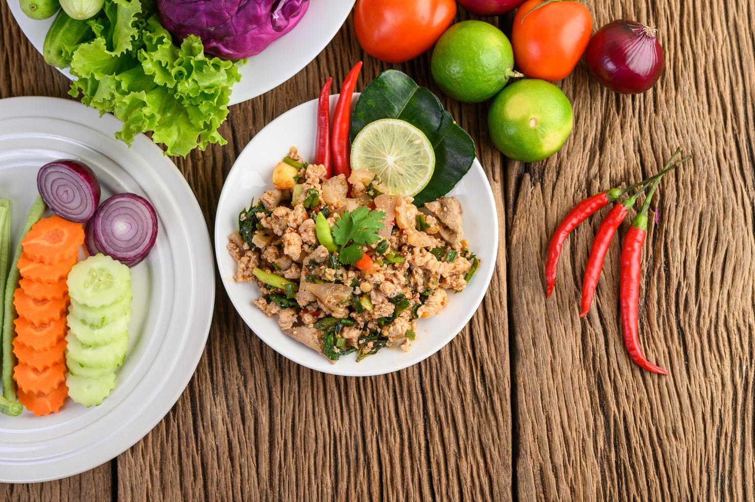 Ensalada de cerdo picada con especias sobre una mesa de madera foto