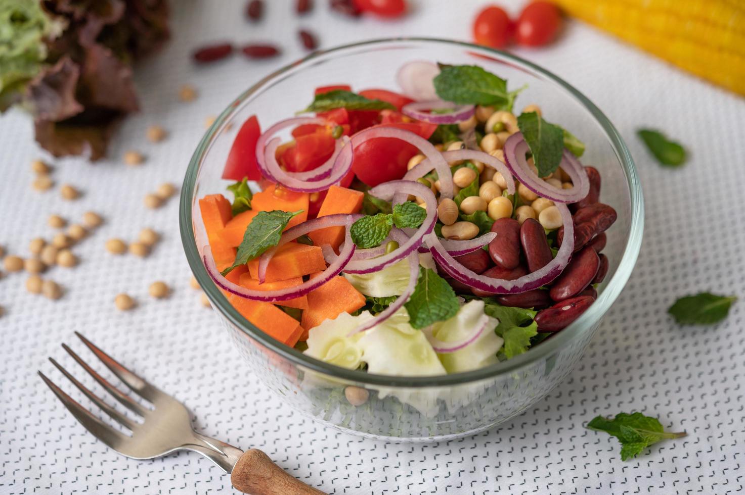 Ensalada de frutas y verduras frescas en un recipiente de vidrio foto