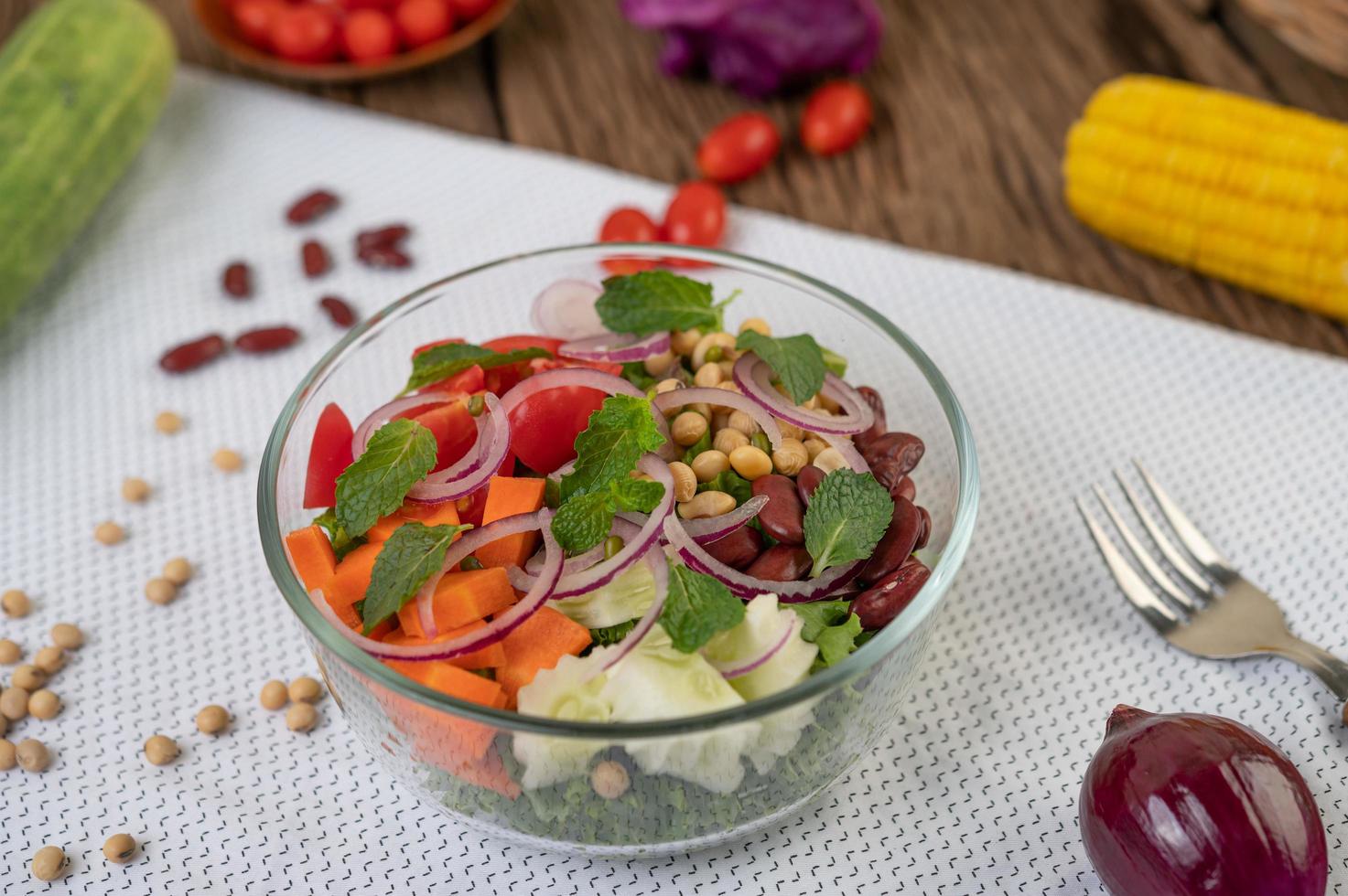 Fresh vegetable and fruit salad in a glass bowl photo