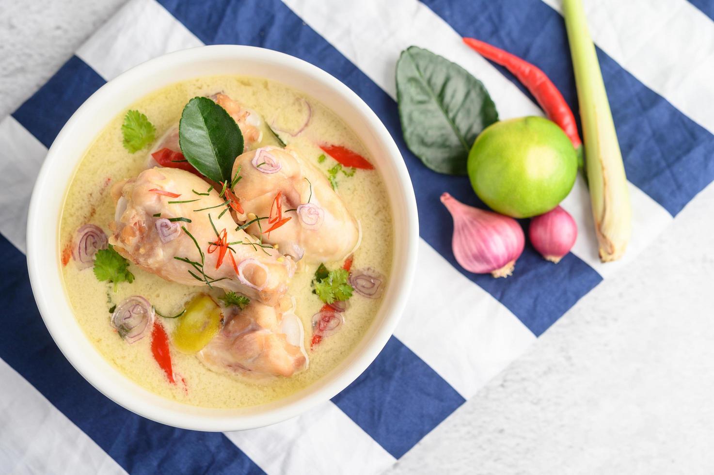 tom kha kai, sopa de coco tailandesa sobre un paño de rayas azules foto