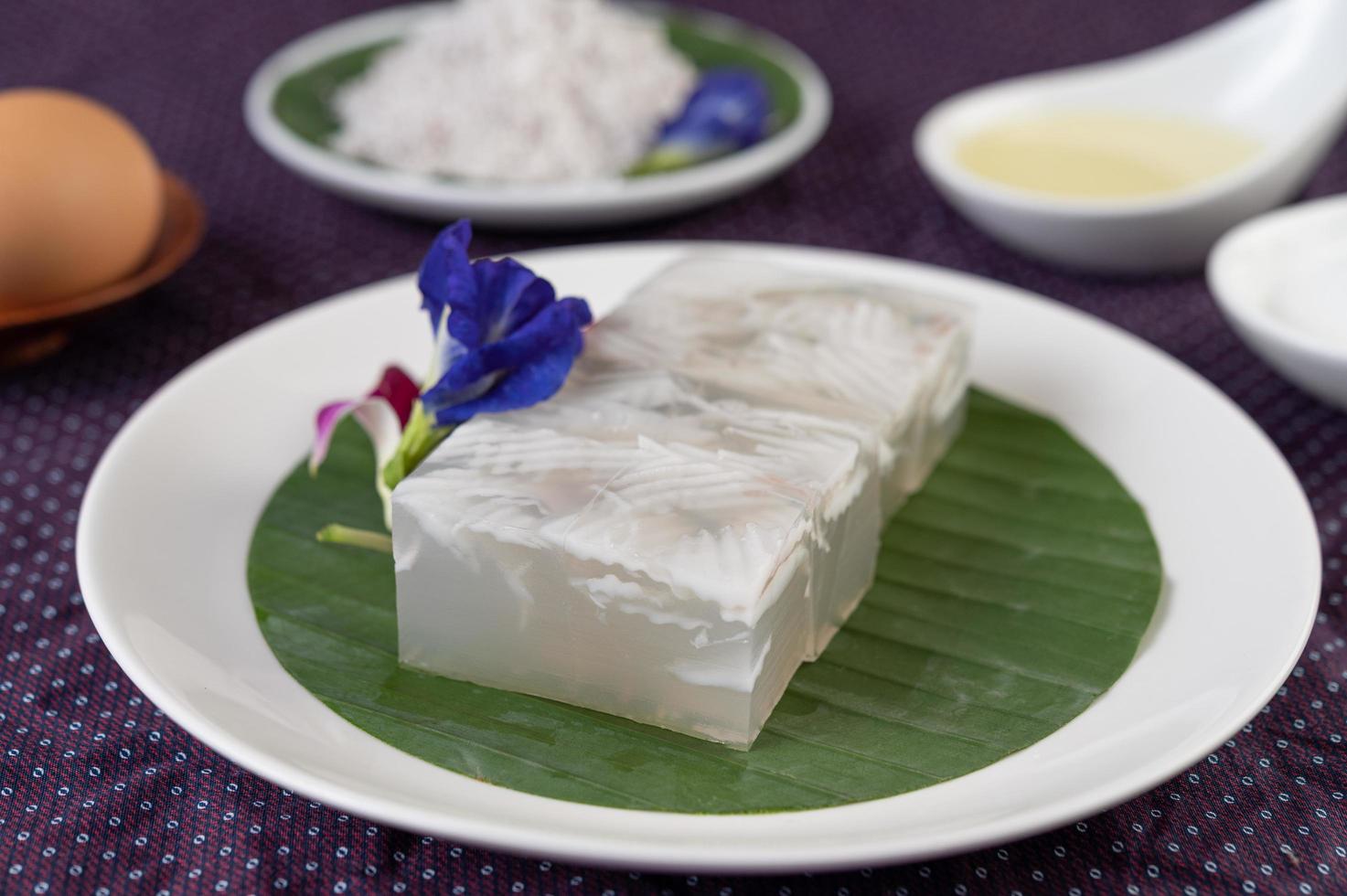 gelatina de coco en una hoja de plátano con flores de guisantes y orquídeas foto