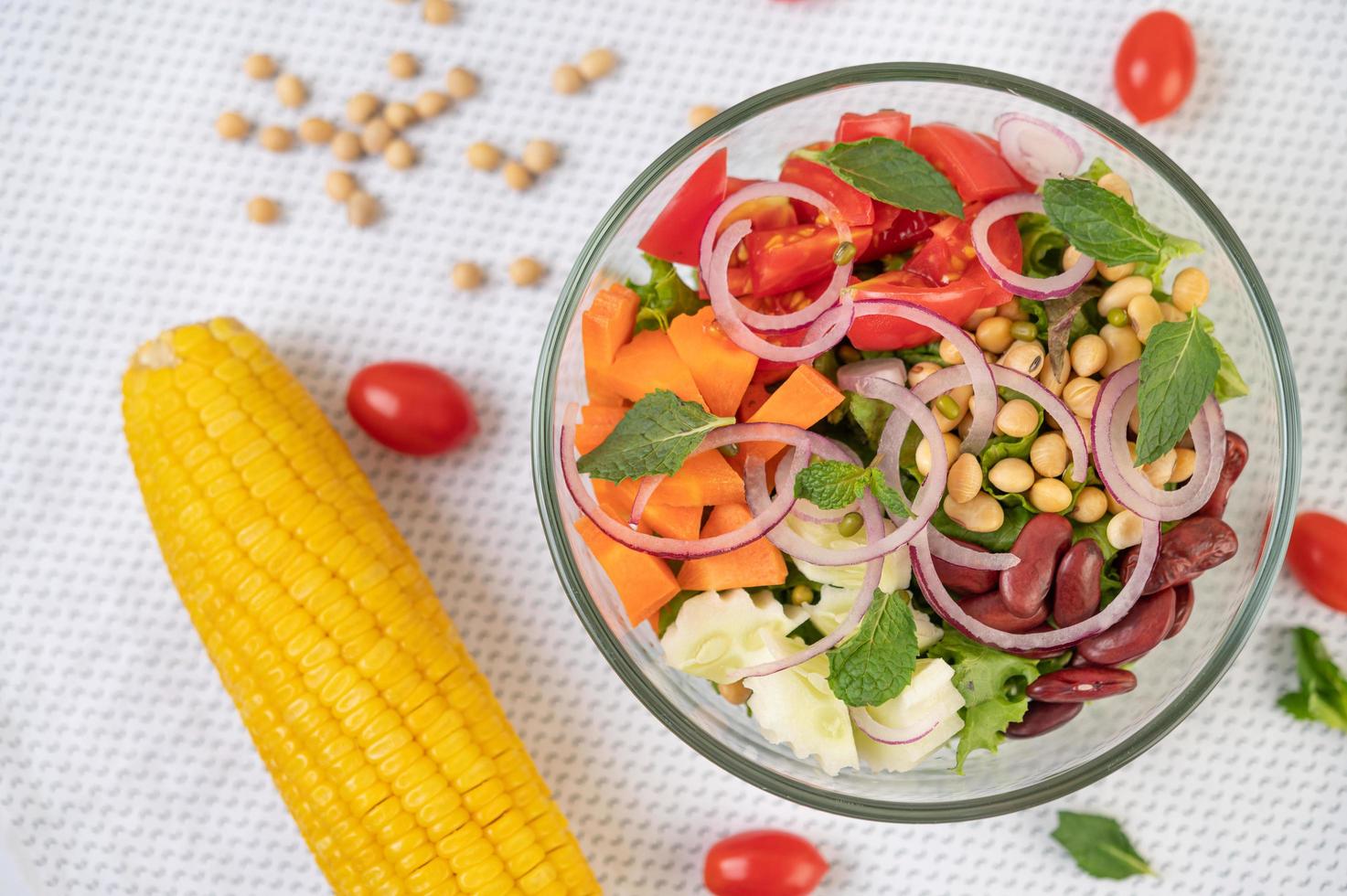 Ensalada de frutas y verduras frescas en un recipiente de vidrio foto