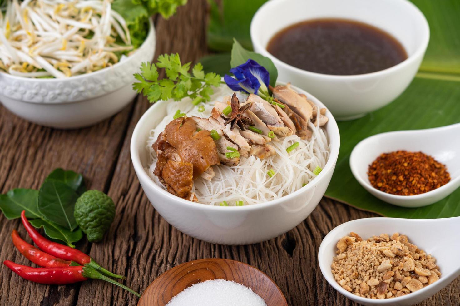 Chicken and noodles in a bowl with side dishes photo