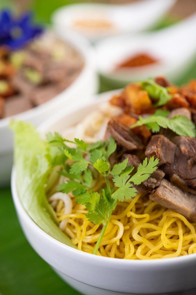 Yellow noodles with crispy pork and meatballs photo