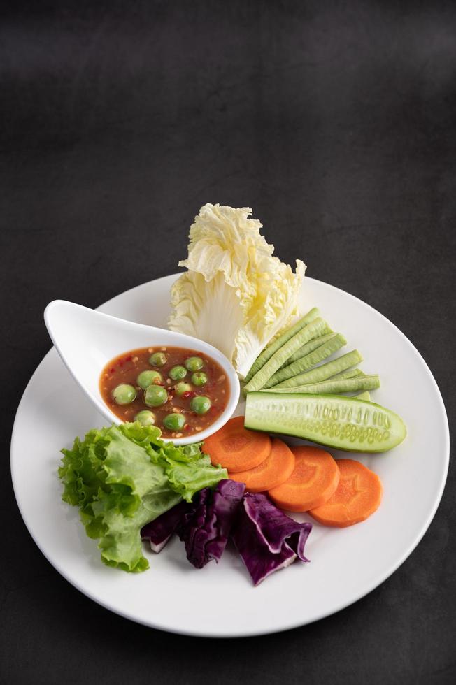 Sauce in a bowl with vegetables photo