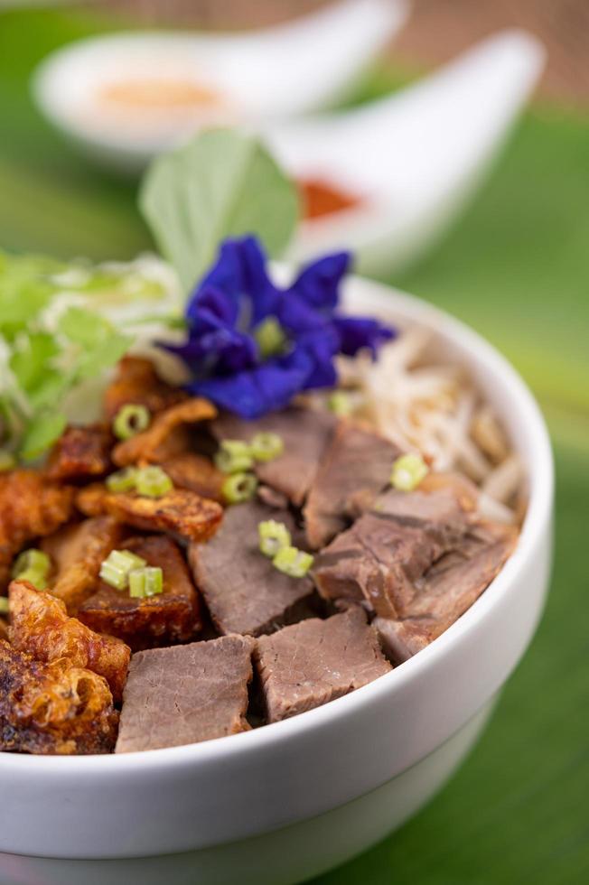 fideos amarillos con crujiente de cerdo y albóndigas foto