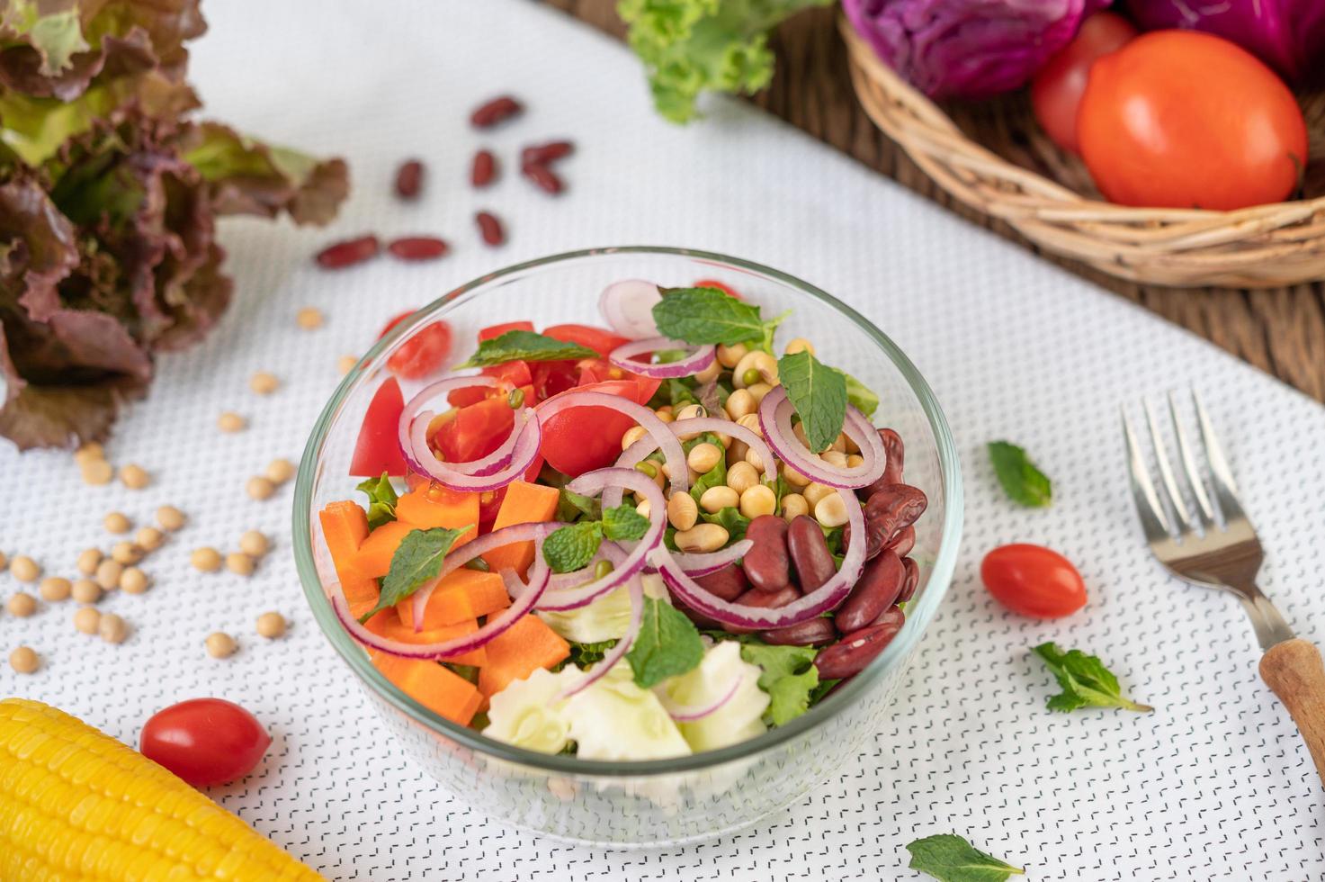 Ensalada de frutas y verduras frescas en un recipiente de vidrio foto