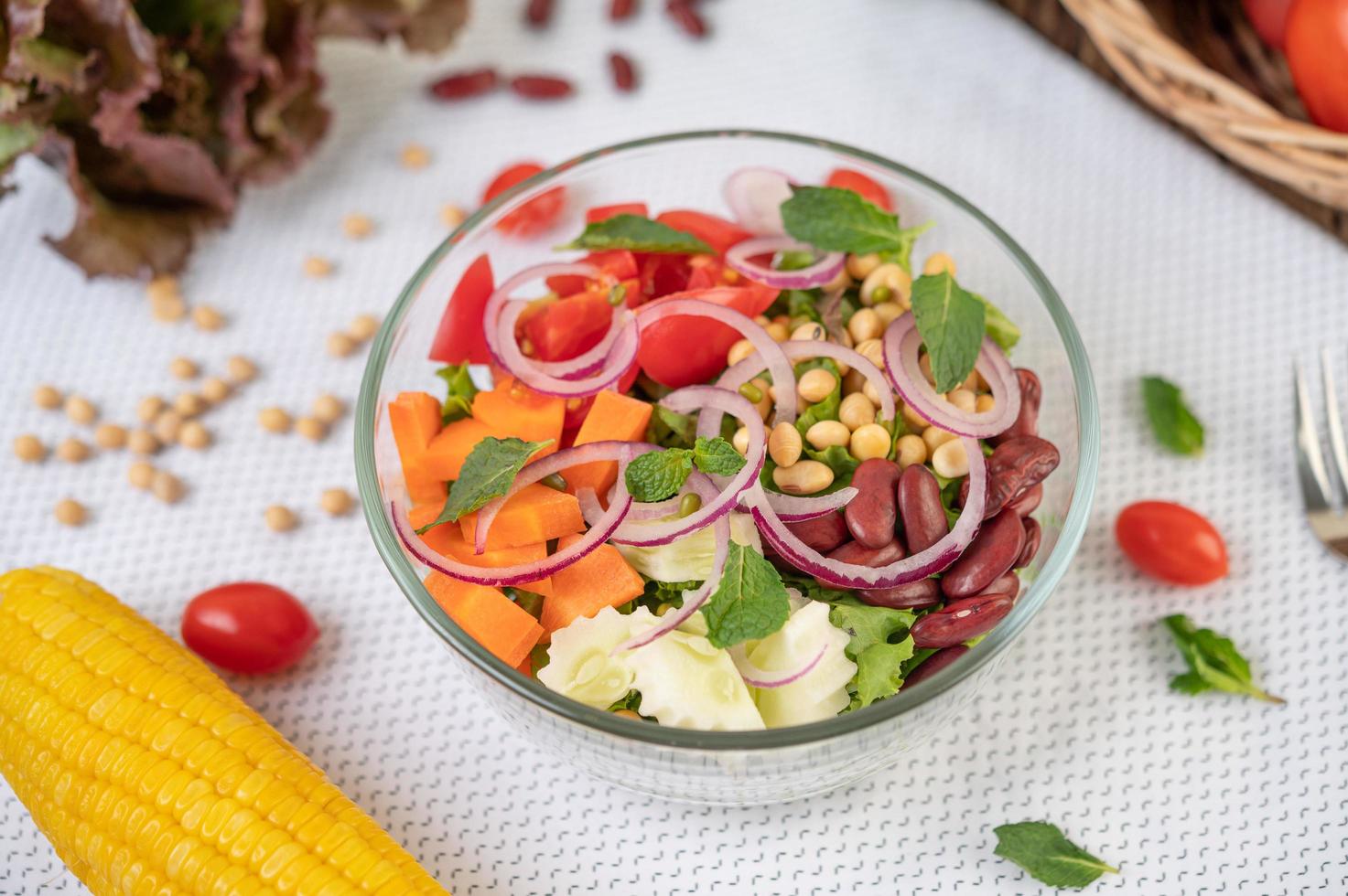 Ensalada de frutas y verduras frescas en un recipiente de vidrio foto