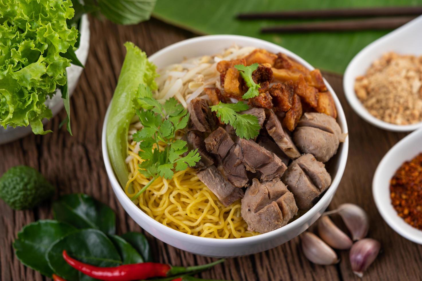 fideos amarillos con crujiente de cerdo y albóndigas foto