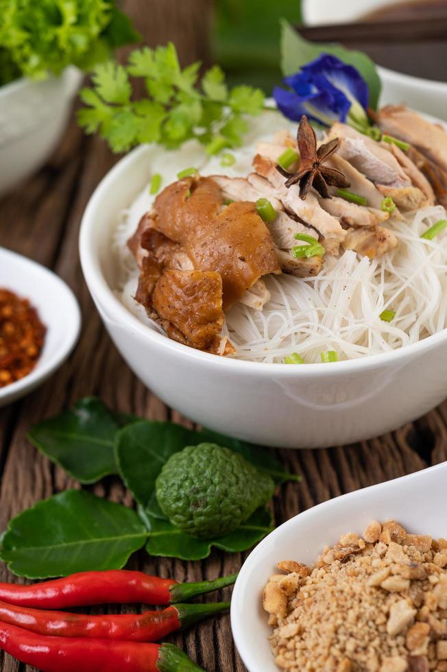 Chicken and noodles in a bowl with side dishes photo
