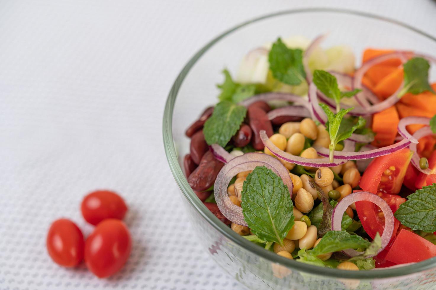 Ensalada de frutas y verduras frescas en un recipiente de vidrio foto