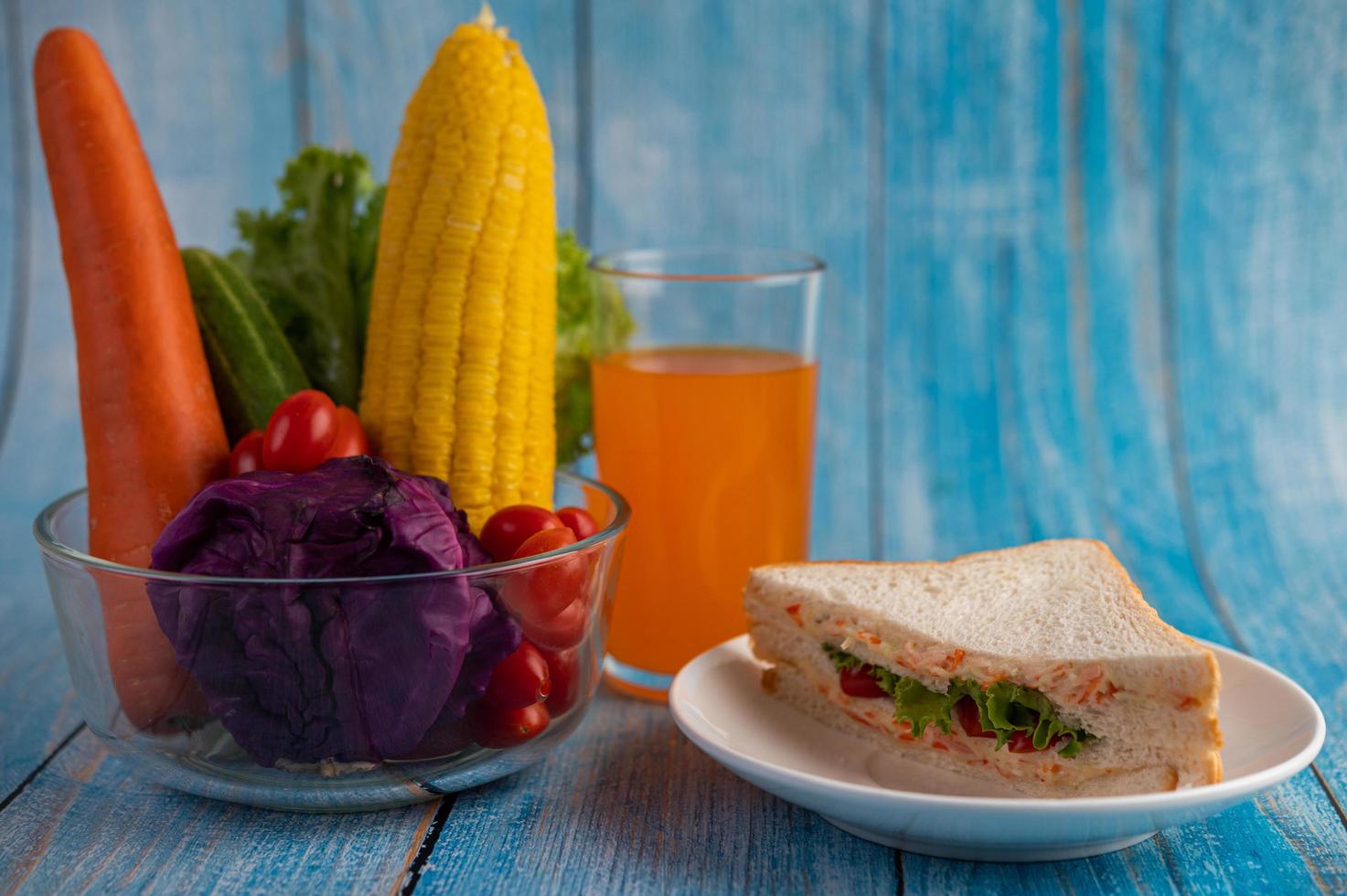 Orange juice, sandwich and vegetables photo