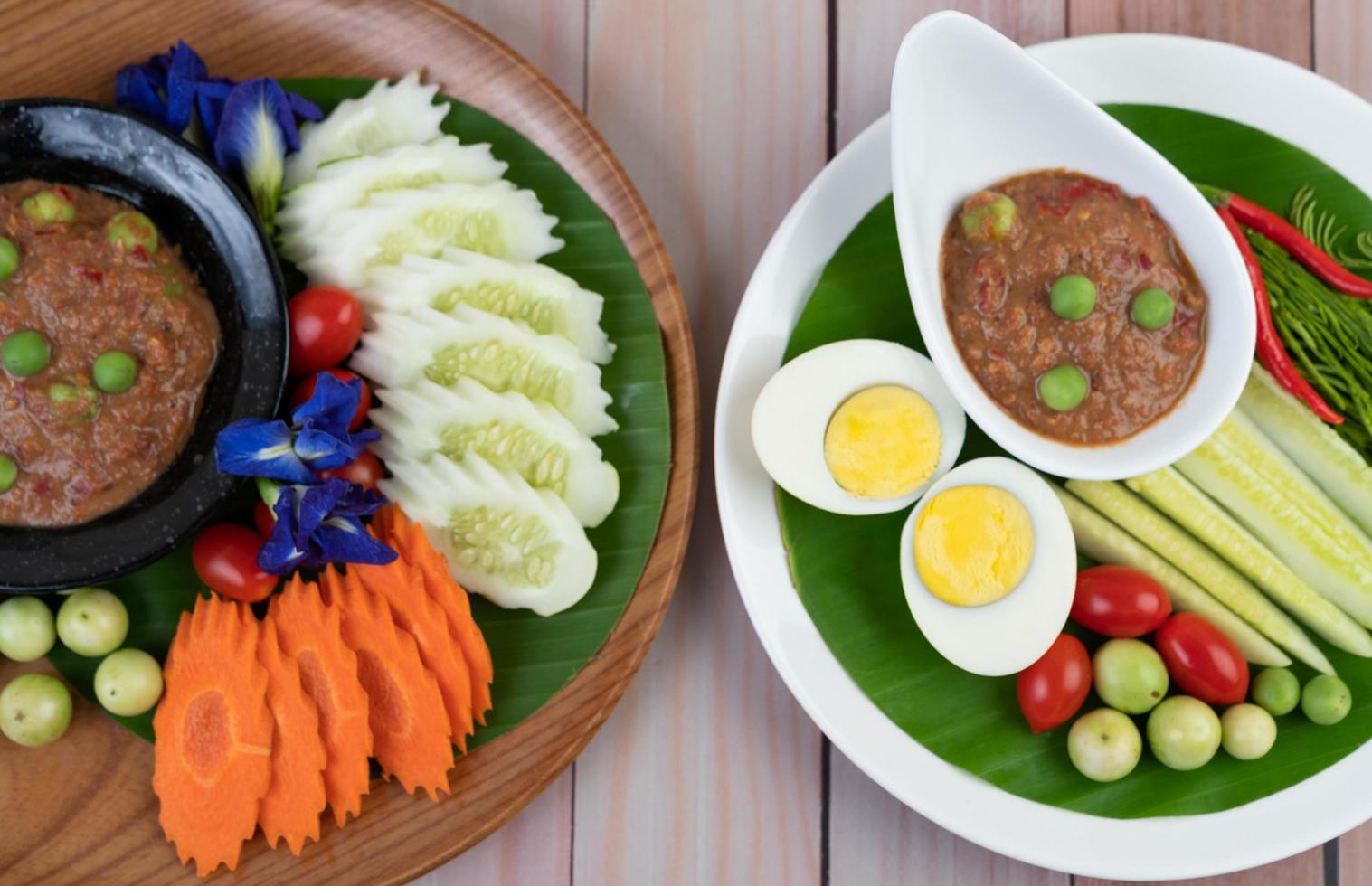 Chili paste paste in a bowl with eggplant, carrots, chili and cucumbers in a basket photo