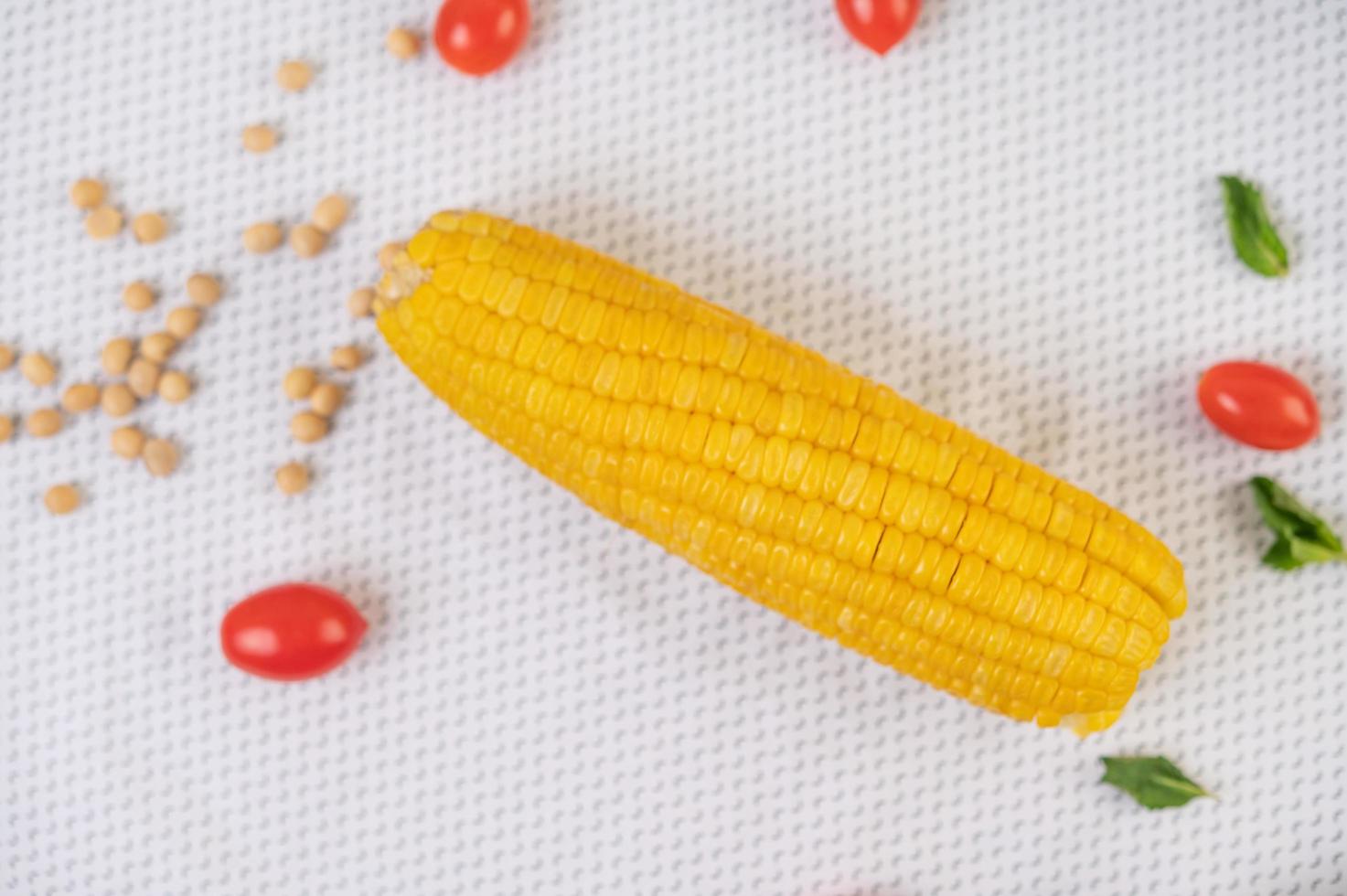 Tomatoes and corn on a white cloth photo