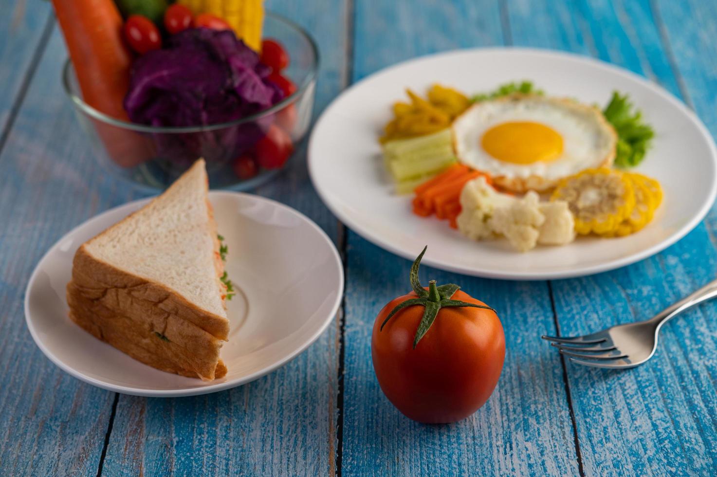 Fried egg breakfast with egg, salad, pumpkin, cucumber, carrot and corn photo